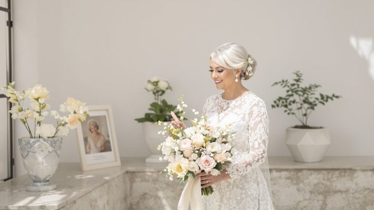 Bride holding a beautiful wedding bouquet in an elegant wedding dress.