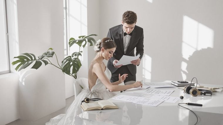 Bride and groom reviewing wedding plans in a bright, modern studio.