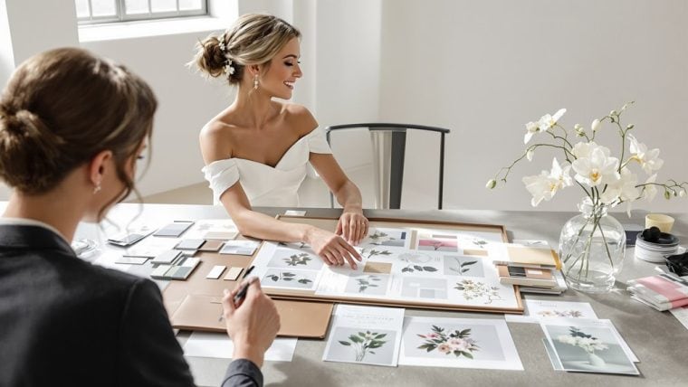 Bride and designer discussing wedding decor and floral arrangements.