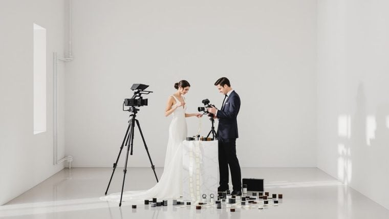 Bride and groom filming wedding scene with professional camera equipment.