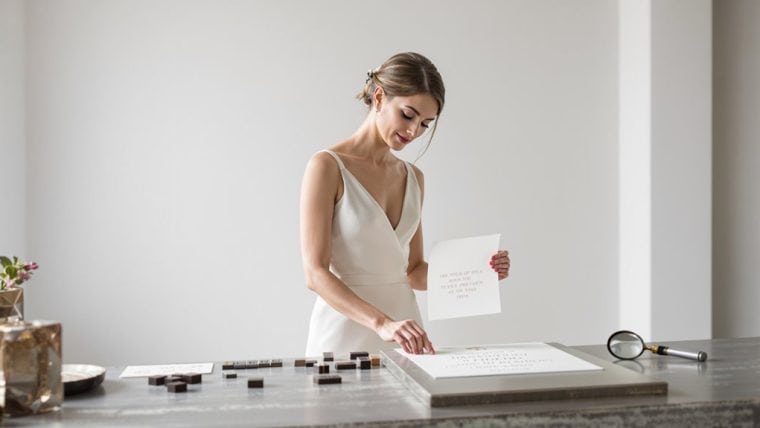 Bride reviewing wedding plans with a checklist in a bright, modern setting.