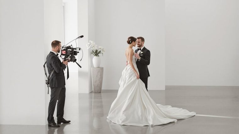 Bride and groom during wedding filming in a minimalist white studio.
