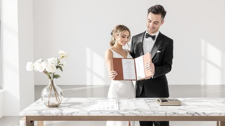 Happy bride and groom reading their wedding vows in a modern, elegant setting.